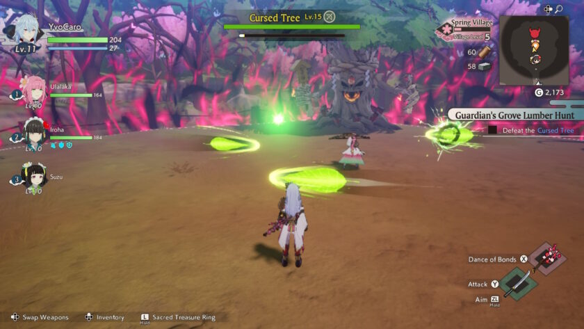 An action battle scene in Rune Factory: Guardians of Azuma where the player character and party members face a monstrous, glowing-eyed tree labeled “Cursed Tree Lv.15.” Bright green projectiles and effects fill the area, while the surroundings are dark and ominous with twisted trees and pink energy. Published on: LadiesGamers