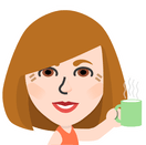 Digital avatar representing a woman with shoulder-length brown hair and bangs, holding a green mug with steam rising from it. She is smiling and wearing an orange top. The style is a colorful, simplified caricature. Published on: LadiesGamers